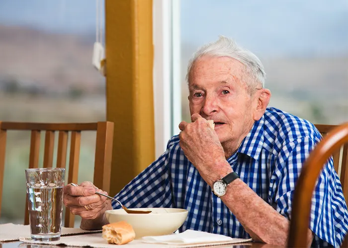 Senior citizen eating a meal