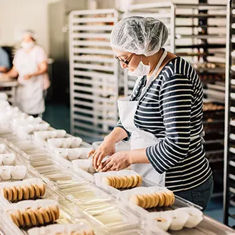 Person prepping packages of food in an industrial kitchen