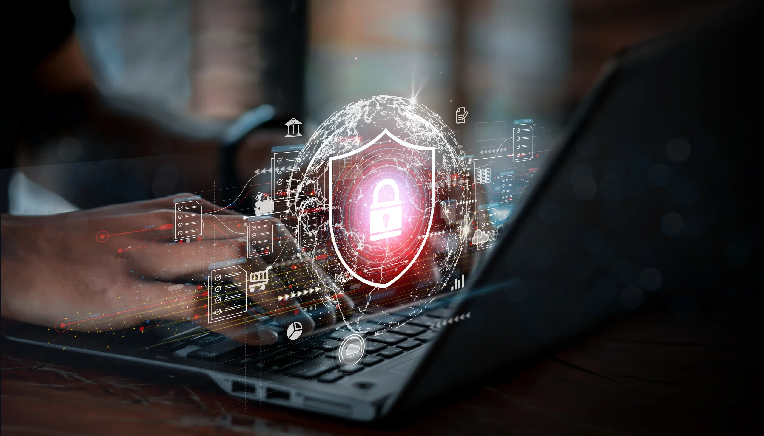 Hands typing on a laptop. A projected image of a shield with a lock is hovering over the keyboard.