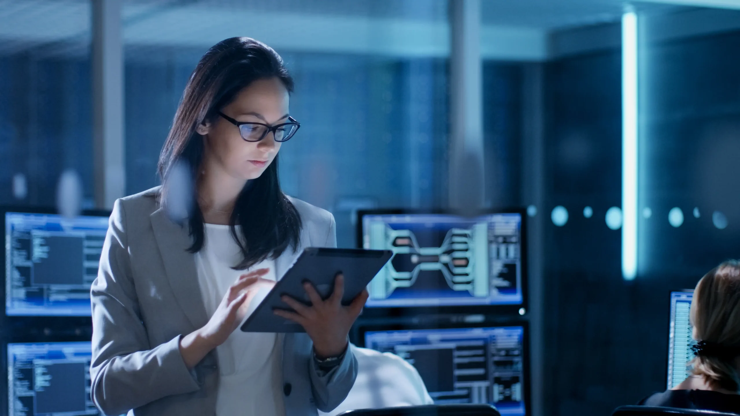 Person standing in a computer lab, using a tablet