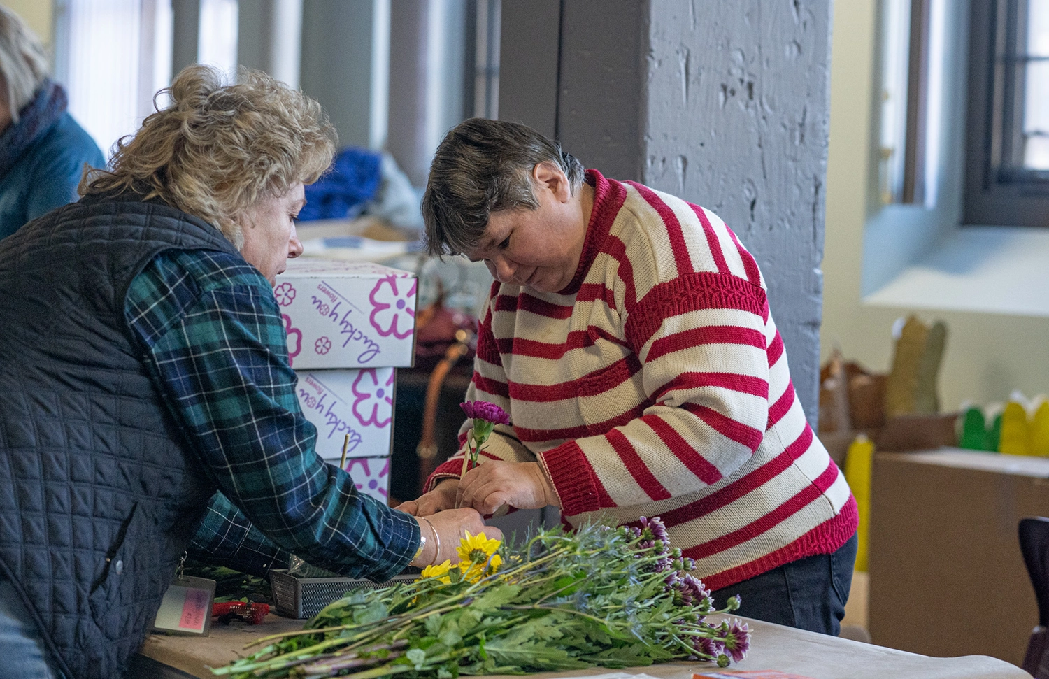 Two people assembling bouquets of flowers