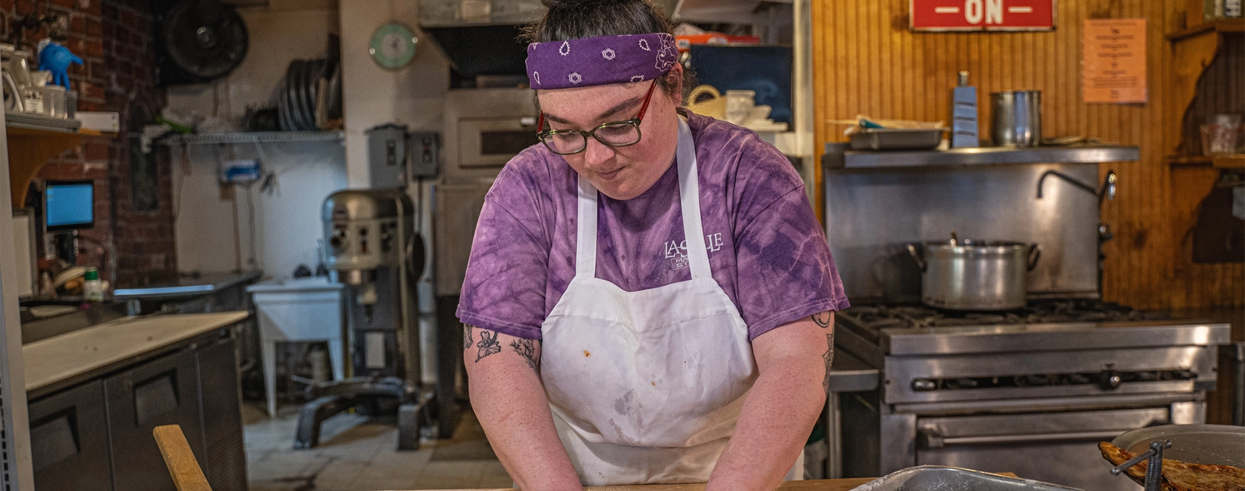 Worker wearing an apron while making something in an industrial kitchen