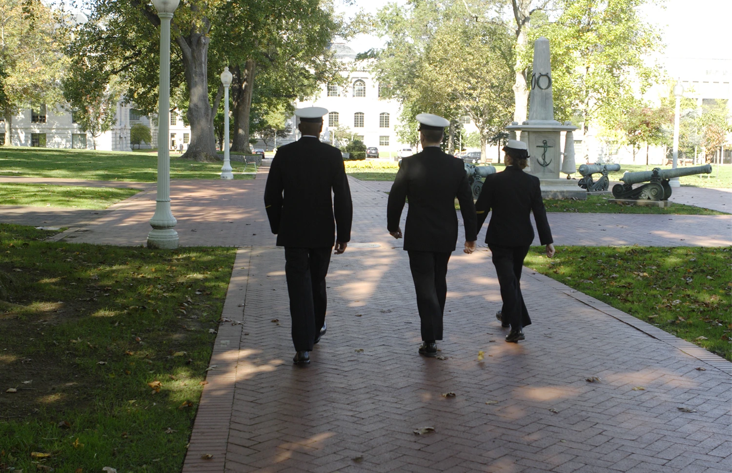 Armed services workers in dress uniforms, walking away from camera